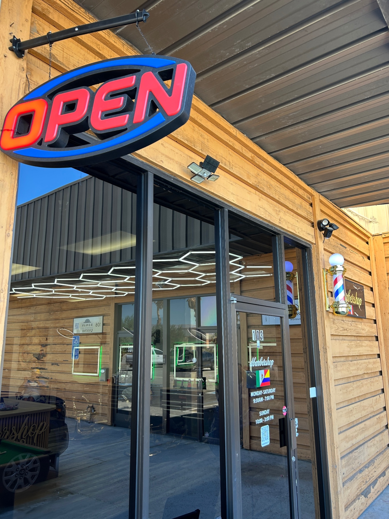 dbarbershop storefront with open sign and barber pole