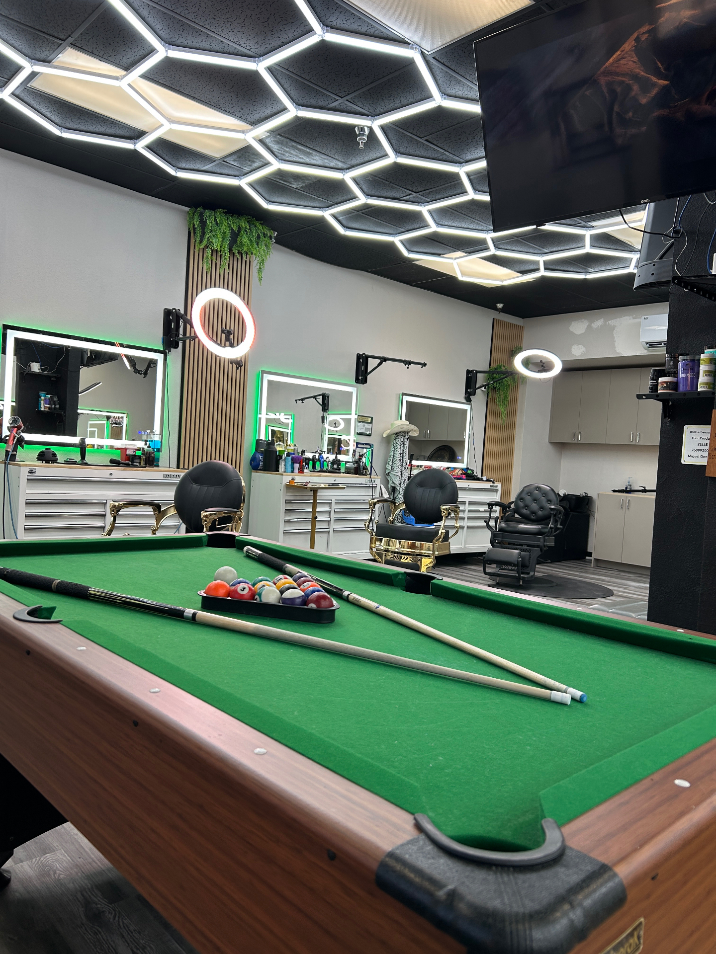 Pool table and barber stations inside dbarbershop