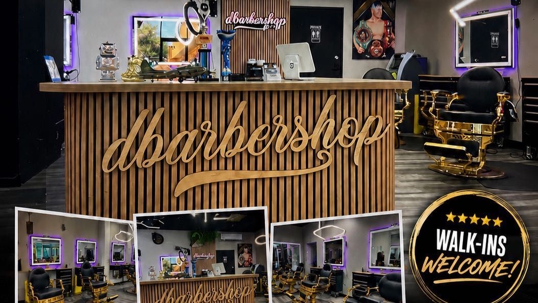 Front desk with the dbarbershop wood sign and barber chairs